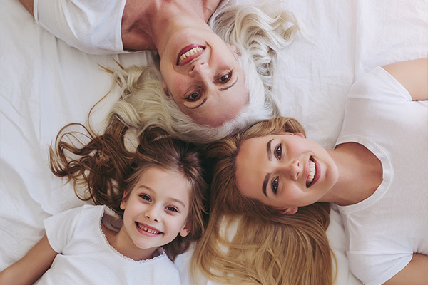 3 generacije žena leže na krevetu