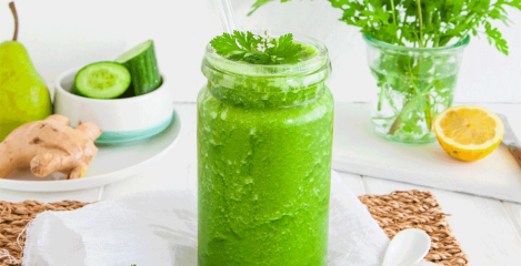 Zeleni smoothie u staklenoj čaši na bijelom stolu.