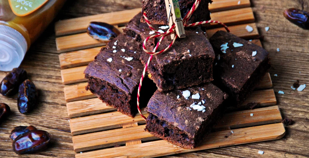Browniesi s datuljama na drvenoj podlozi.