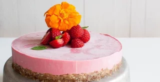 Crvena torta iz blendera s jagodama na bijeloj pozadini.