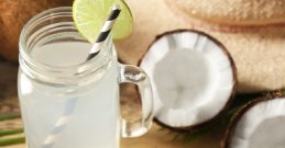 Kokosova voda u staklenoj čaši na drvenom stolu.