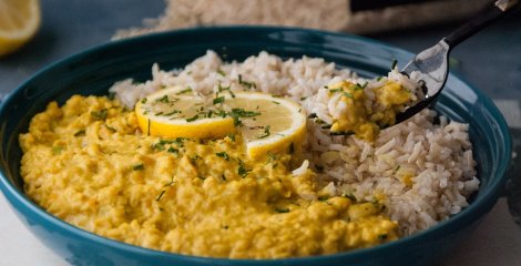 Žuta curry leća s rižom u crnom tanjuru
